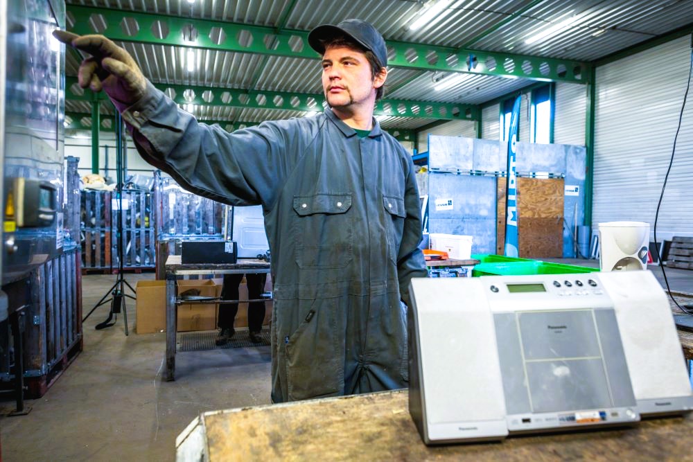 Worker at sheltered workshop Mirto catagolising a discarded electrical appliance for Recupel