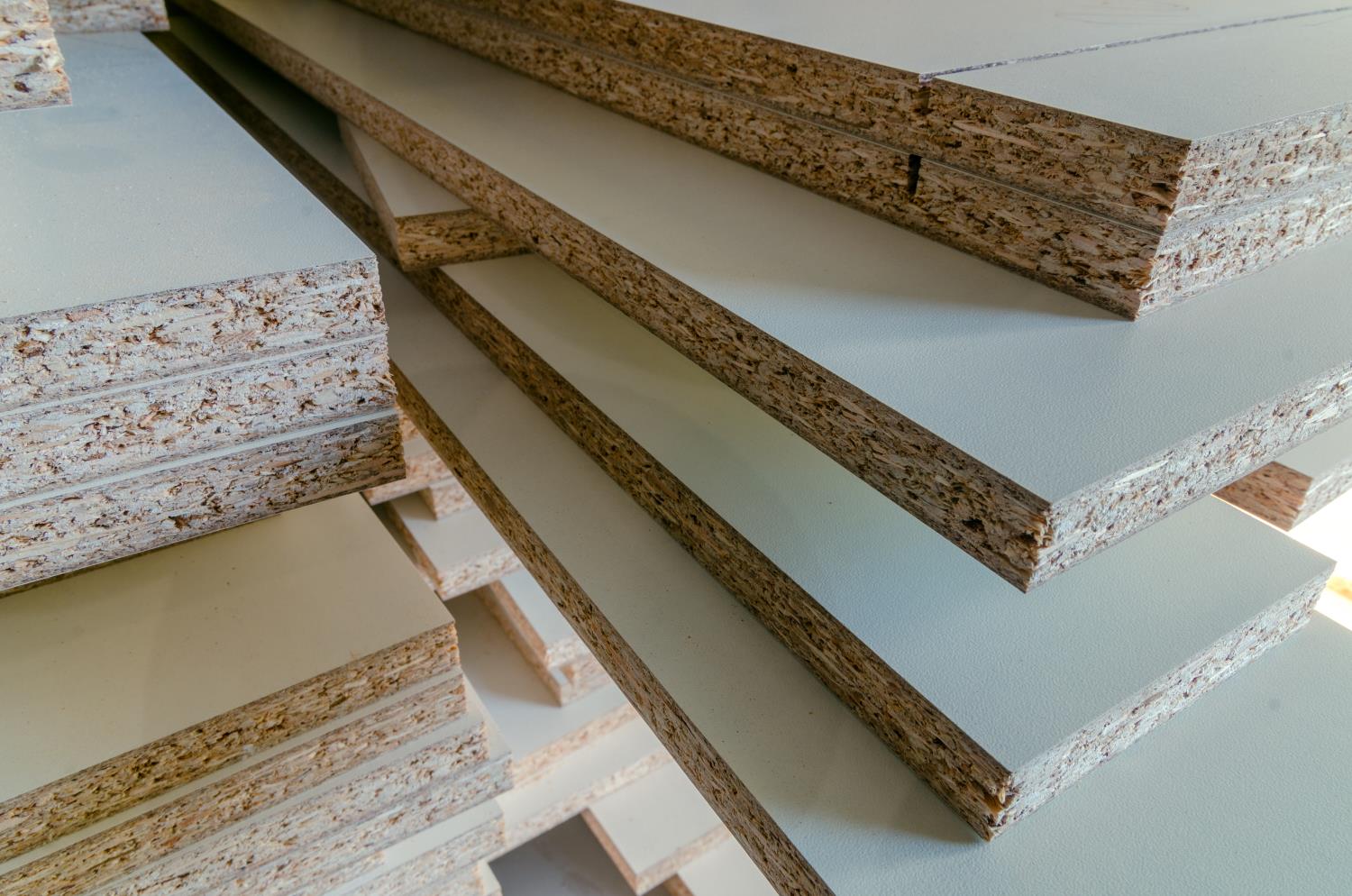 Image of chipboards with a melamine finish stacked on top of each other.