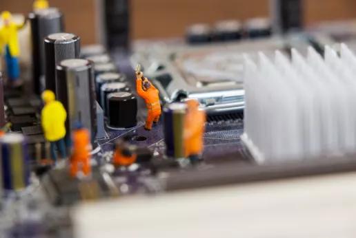 Miniatuurpopjes van remanufacturing werkmannen op realsize moederbord