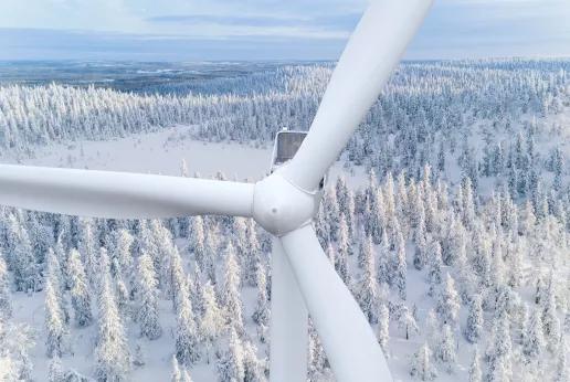Wind turbine aerial view in snow covered woods in Finland
