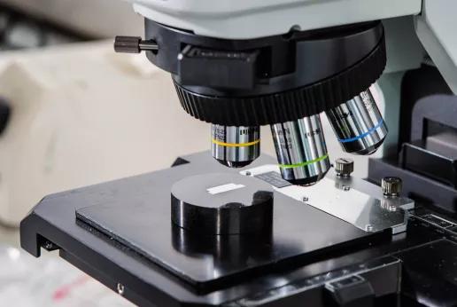 Close-up van een testmonster onder een microscoop in het Sirris Metal Lab, gebruikt voor metallografische analyse.