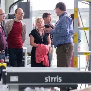 Sirris expert explaining production strategy to a group of visitors in the Sirris Lab at Facthory in Genk, with a AMR in the foreground
